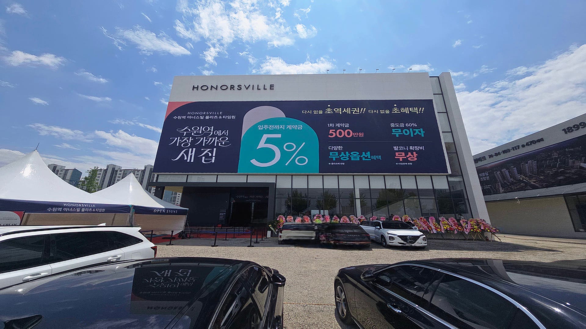 1차 계약금 500만 원과 중도금 무이자 혜택을 홍보하는 수원역 아너스빌 플라츠 모델하우스 외부 현수막