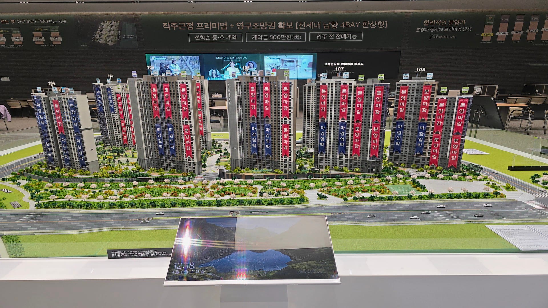 각 동마다 분양 마감 및 마감 임박을 알리는 붉은색과 푸른색 현수막이 걸려 있는 브레인시티 앤네이처 미래도 1,413세대 단지 모형도